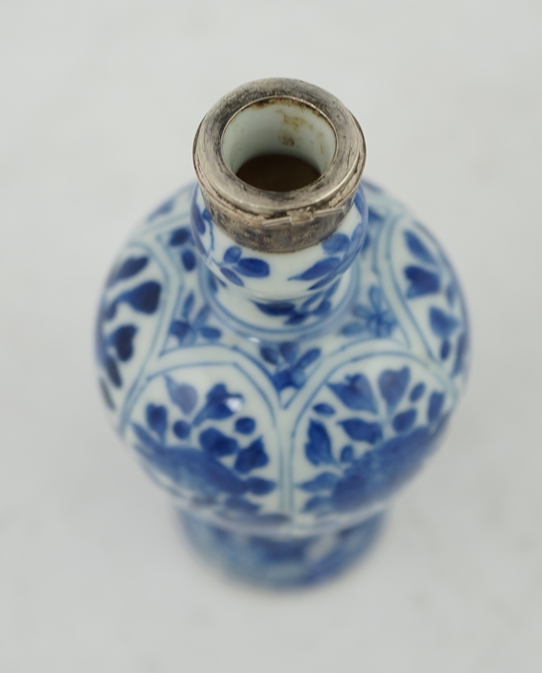 A Chinese small blue and white, white metal mounted vase, Kangxi, 12cm. Condition - poor to fair